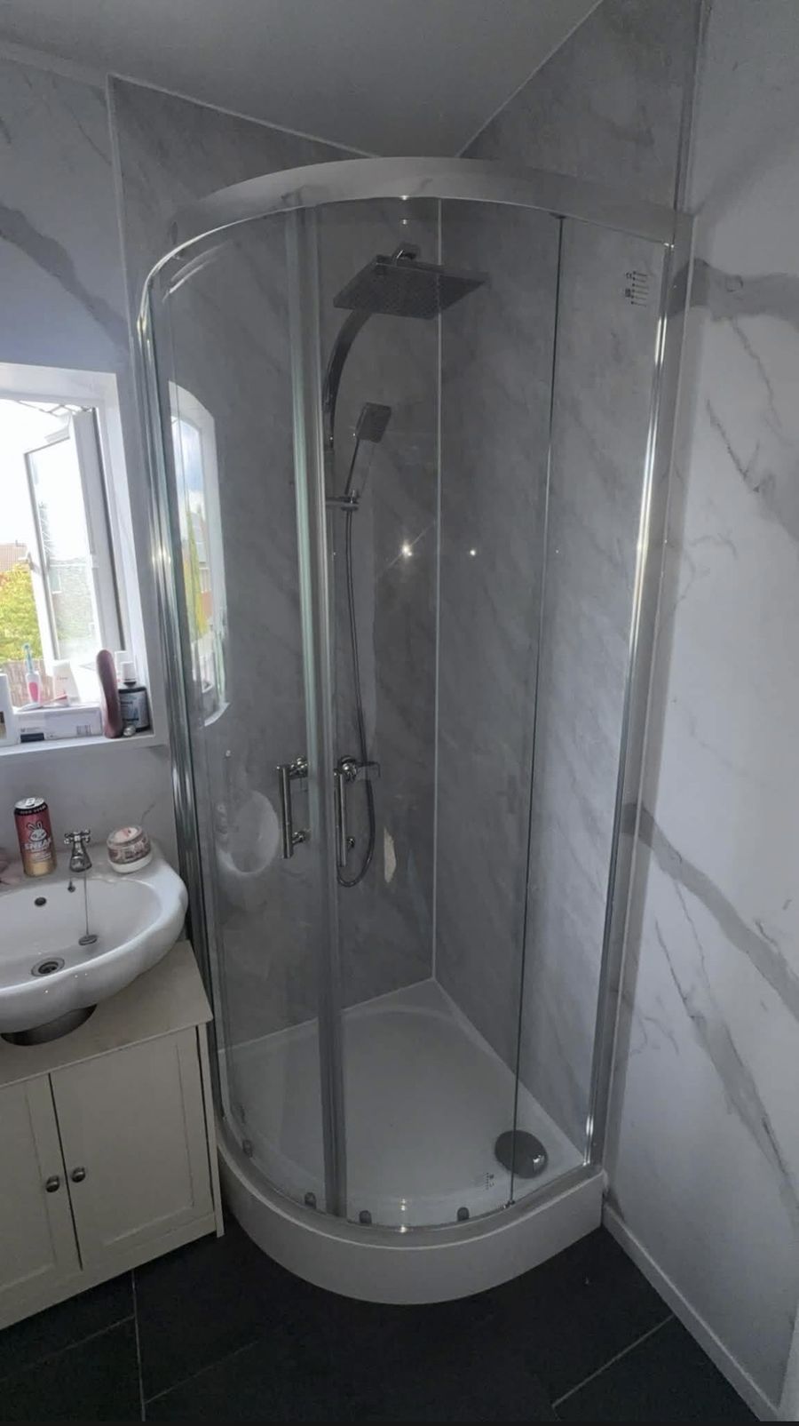 Renovated bathroom by Jacob Conway Plumbing Services with curved glass shower enclosure